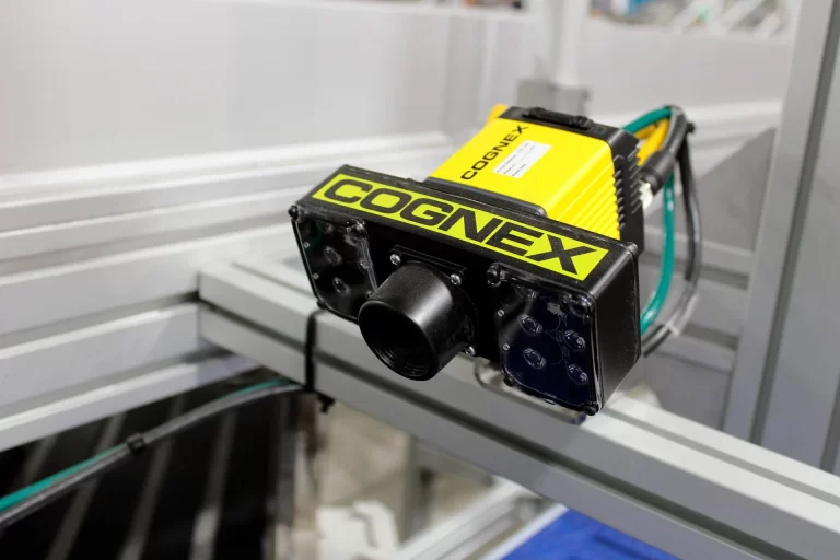 Cámara Cognex detectando y clasificando productos en una línea de producción automatizada.